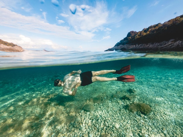 Homme au masque de plongée plongée en apnée dans l'eau de mer Grèce vacances