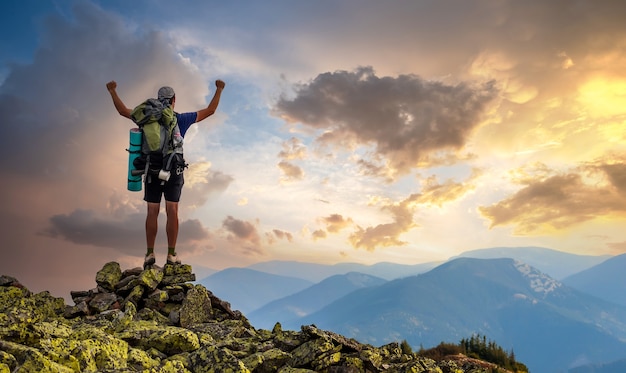 homme au sommet de la montagne. scène émotionnelle. jeune homme avec sac à dos