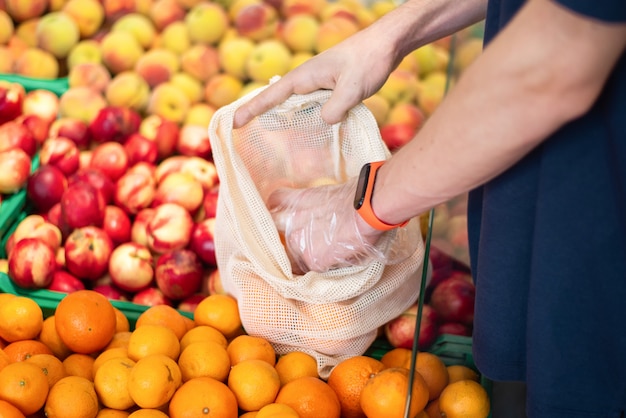 Homme au supermarché avec sac écologique prenant des produits