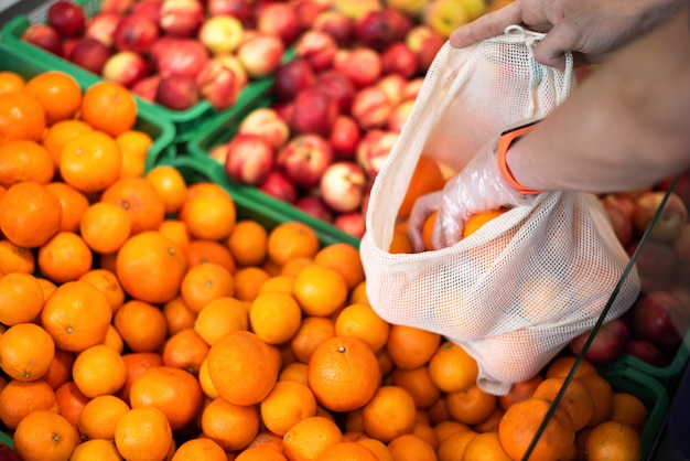 Homme au supermarché avec sac écologique prenant des produits