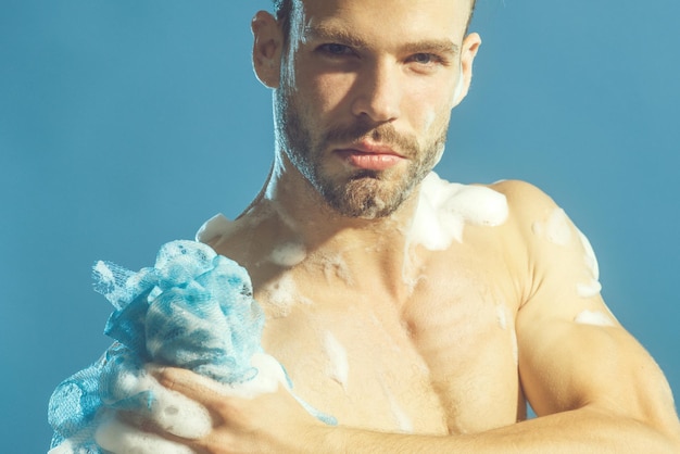 Homme au torse nu est lavé dans la douche homme barbu sexy laver le corps musclé bel homme