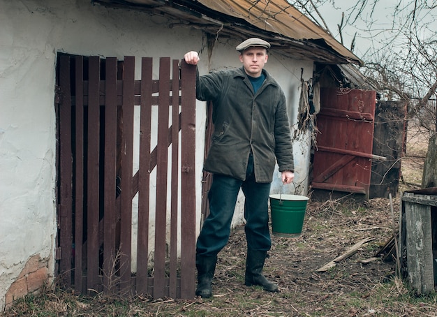 Homme au village avec seau d'eau