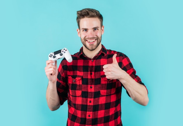 Un homme aux cheveux et à la barbe soignés à la mode joue à un jeu d'ordinateur avec le gagnant de la console