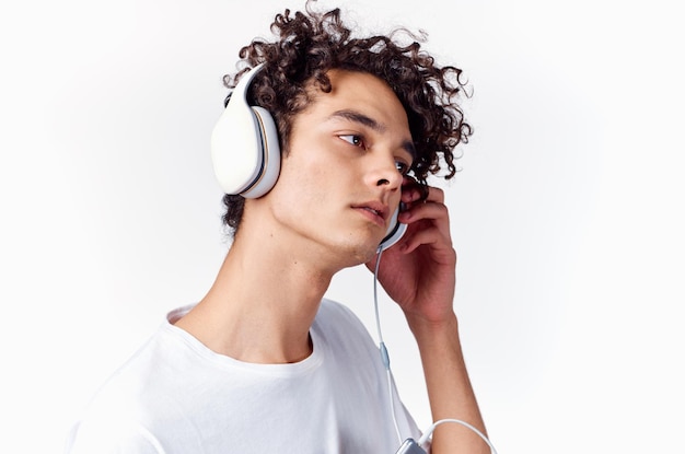 Homme aux cheveux bouclés portant des écouteurs musique émotions closeup