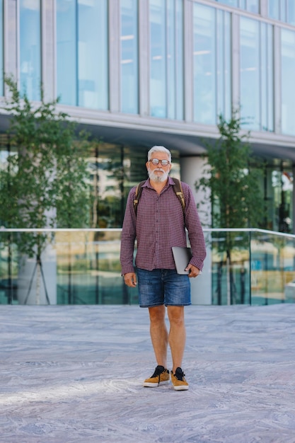 Un homme aux cheveux gris adulte avec une barbe se rend au bureau pour travailler avec un homme d'affaires senior en chemise