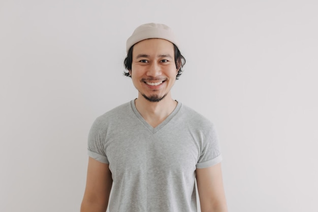 Homme aux cheveux longs et à la barbe en t-shirt gris et casquette isolé sur blanc