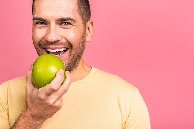 Homme aux dents blanches parfaites et pomme verte. Montrant des dents et un sourire parfaits.