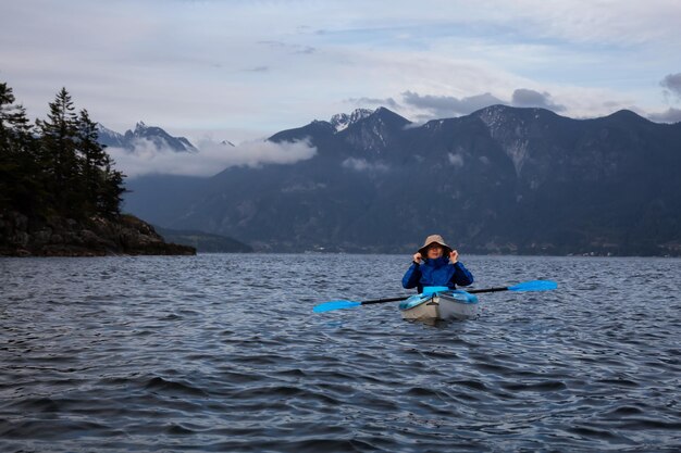 Un homme aventureux sur un kayak pagaie dans la baie Howe