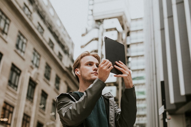 Homme ayant un appel vidéo sur sa tablette numérique dans une ville