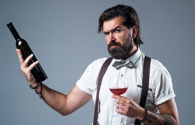 Homme ayant un déjeuner d'affaires au restaurant buvant du vin rouge tenant un verre et une bouteille d'acclamations