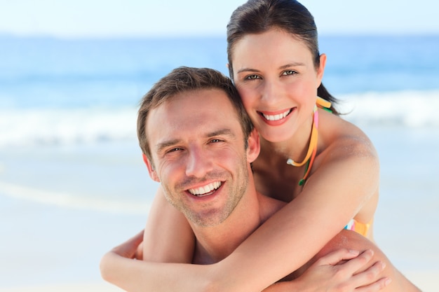 Homme ayant une femme un ferroutage sur la plage