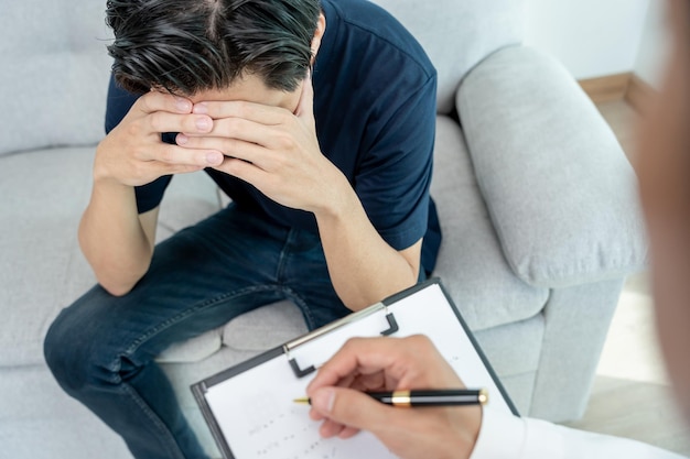 un homme ayant des problèmes de santé mentale consulte un psychiatre enregistre l'état du patient pour un traitement encouragement problème d'amour et de famille dépression bipolaire le patient protège le suicide