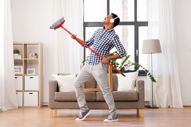 Photo un homme avec un balai qui nettoie et s'amuse à la maison