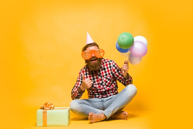 Homme avec des ballons célébration homme de fête avec des vacances présentes