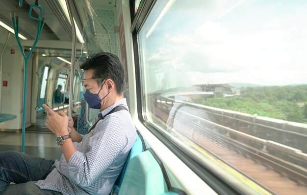 Homme de banlieue avec masque facial à l'intérieur d'une rame de métro en mouvement