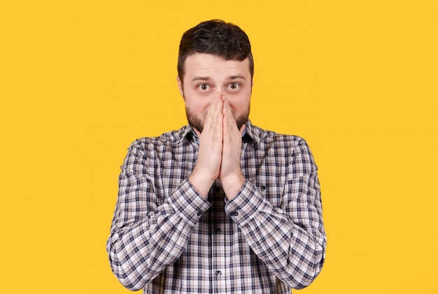 Homme à barbe choqué, isolé sur un espace jaune.