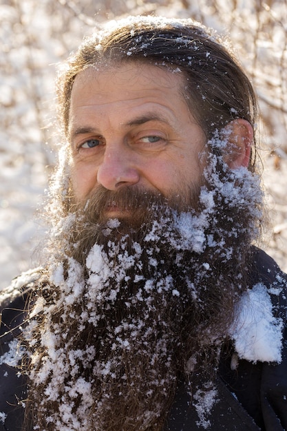 Un homme avec une barbe dans la neige, l'air en colère.