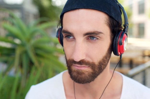 Homme à la barbe en écoutant de la musique sur les écouteurs