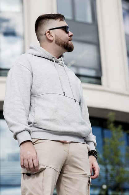 un homme à la barbe élégant dans un capuchon gris