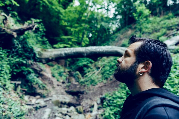 Homme à la barbe en levant dans la forêt