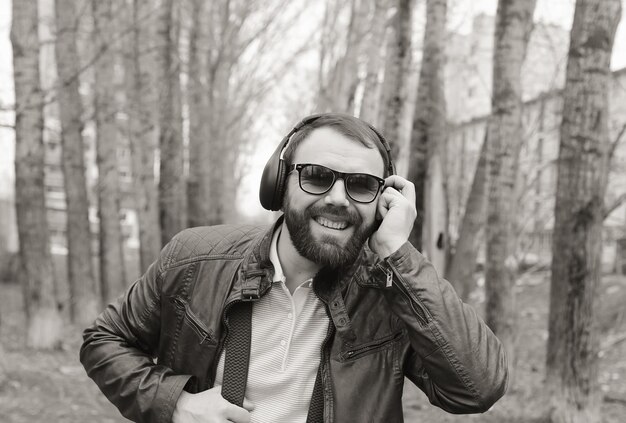 Homme barbe monochrome écouter de la musique dans le parc