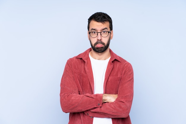 Homme à barbe sur mur bleu isolé