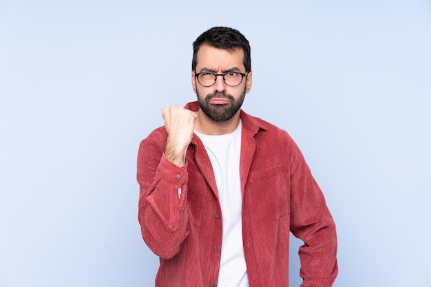 Homme à barbe sur mur bleu isolé