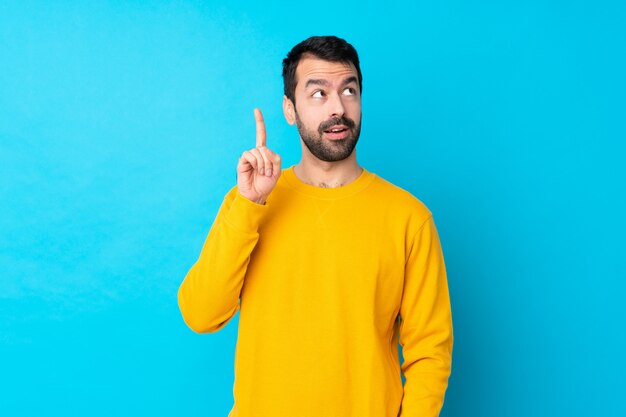 Homme à barbe sur mur bleu isolé