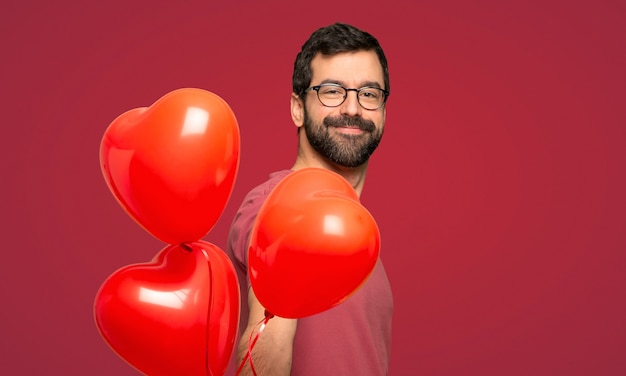 Homme à la barbe en Saint Valentin sur fond rouge