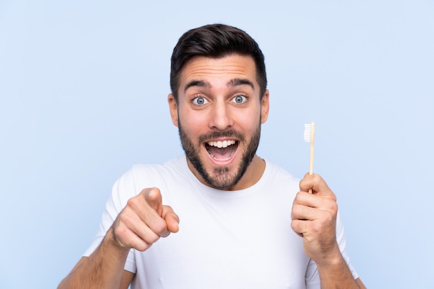 Homme à barbe se brosser les dents sur le mur isolé