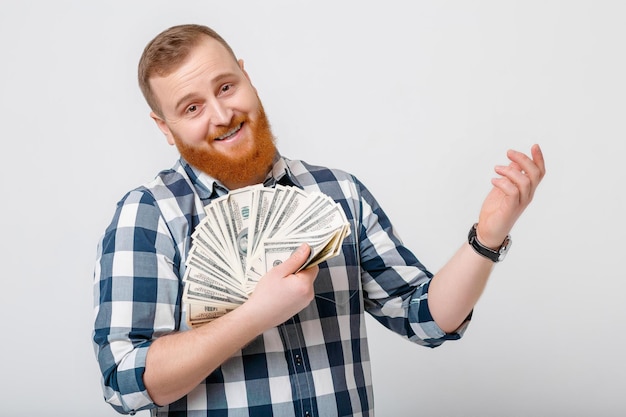 Homme avec barbe tenant beaucoup de billets de cent dollars