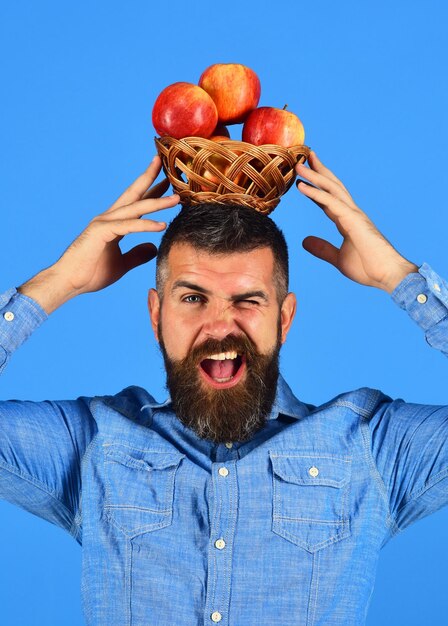 Photo l'homme à la barbe tient un bol en osier avec des fruits