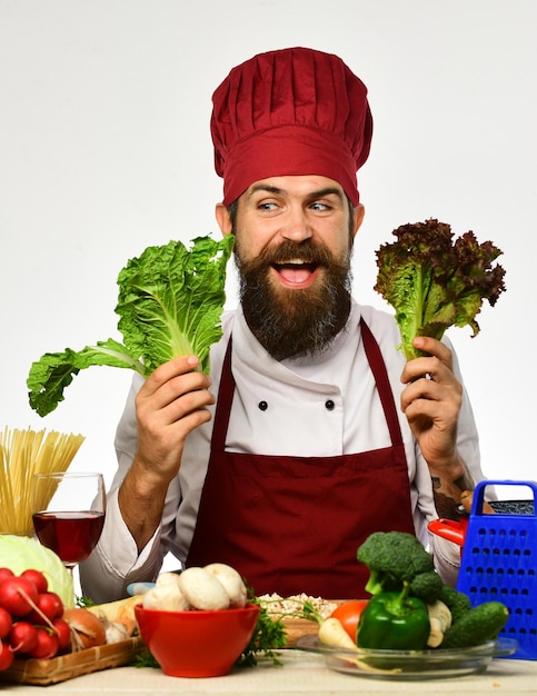 L'homme avec la barbe tient la laitue sur le fond blanc