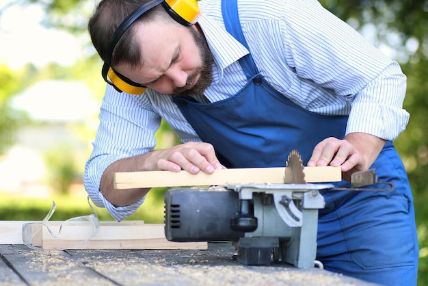 homme barbe travaillant sur scie circulaire