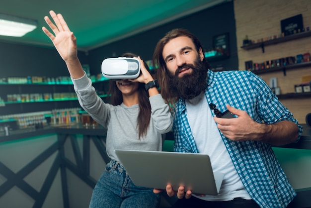 Photo homme à la barbe utilise des cigarettes électroniques dans le magasin de vape.