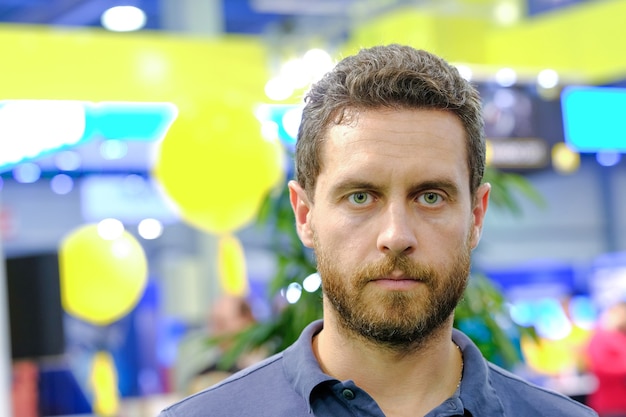 Photo homme avec barbe sur visage sérieux pose sur fond coloré flou. beauté, mode, concept de barbier. espace de copie