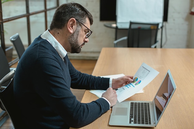 Homme barbu adulte réfléchi analysant des informations commerciales