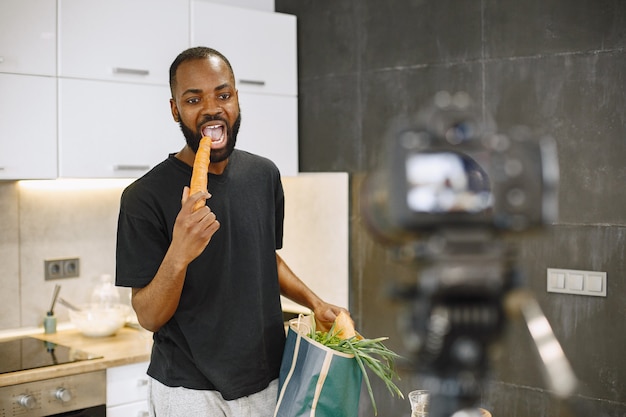 Homme barbu afro-américain souriant et tenant un paquet avec de la nourriture