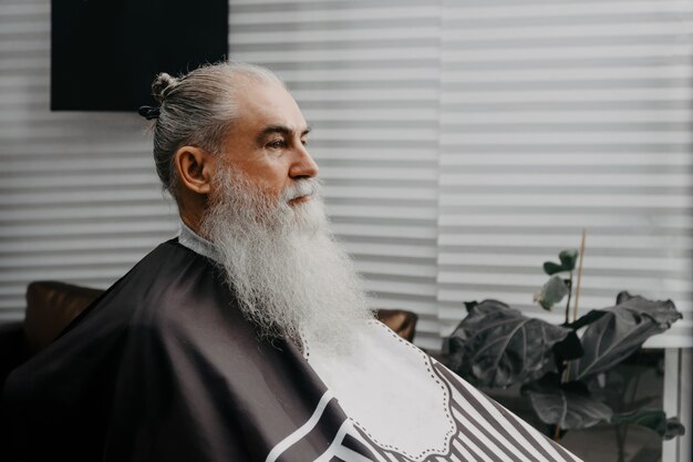 Homme barbu âgé en attente dans un salon