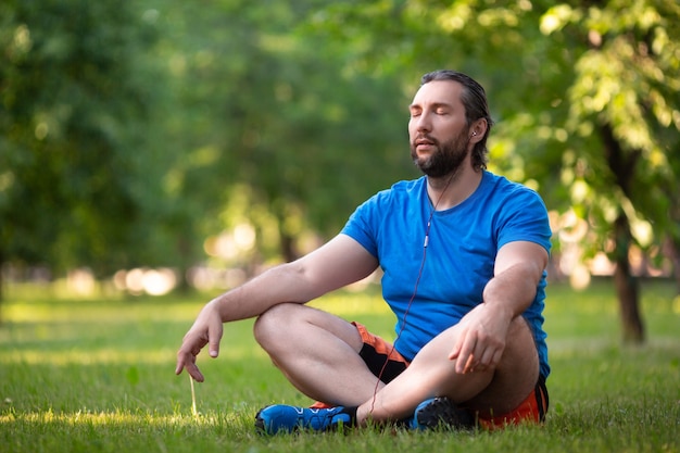 Homme barbu d'âge moyen en lotus pose en plein air