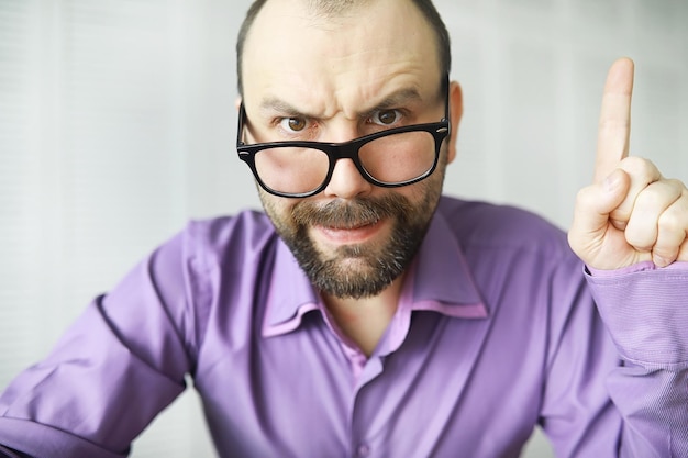 Un homme barbu aux yeux croisés regarde dans le cadre Maladie des yeux Le concept d'un spécialiste inexpérimenté Voisin espion