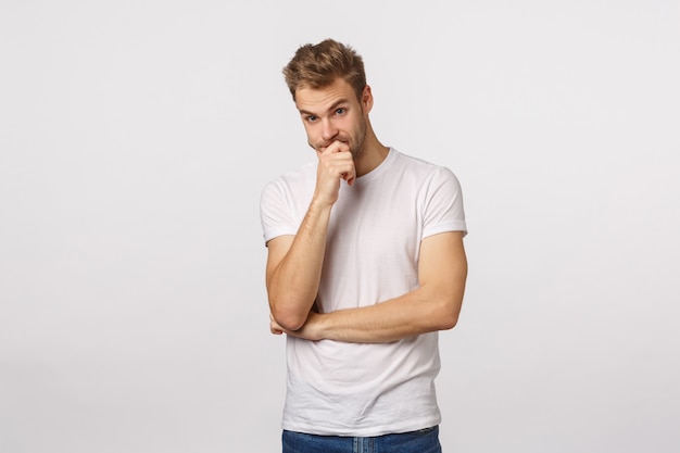 Homme barbu blond séduisant en pensée de T-shirt blanc