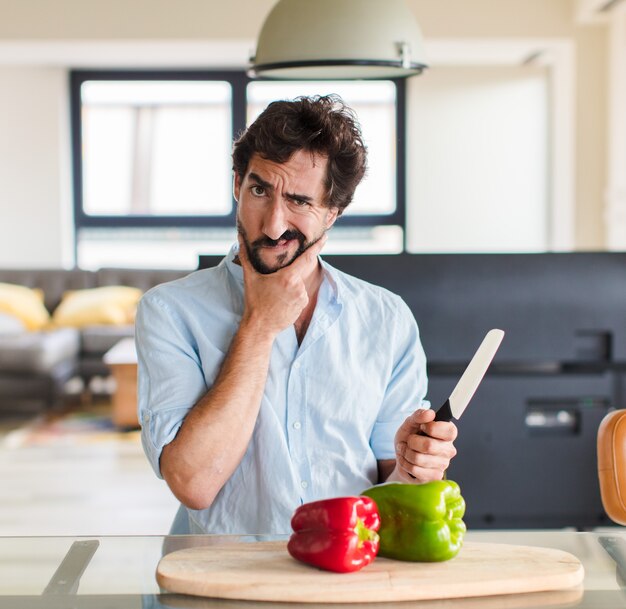 Homme barbu avec la bouche et les yeux grands ouverts et la main sur le menton, se sentant désagréablement choqué