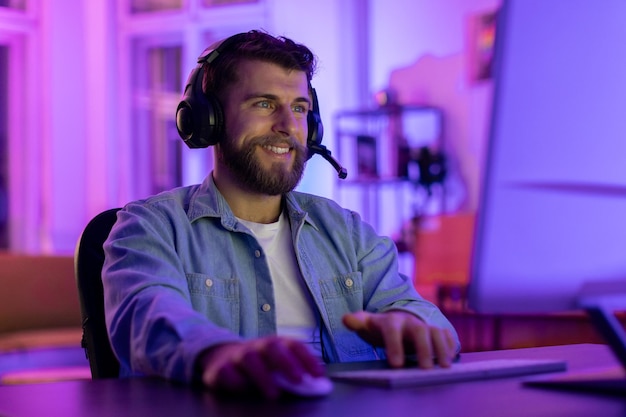 Un homme barbu avec un casque à l'ordinateur