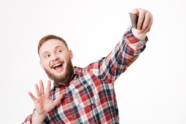 Homme barbu en chemise faisant selfie