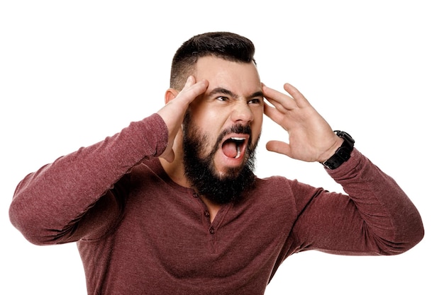 Homme barbu en colère criant sur fond blanc.