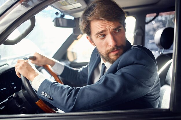 Homme barbu en costume dans une voiture un voyage pour travailler riche