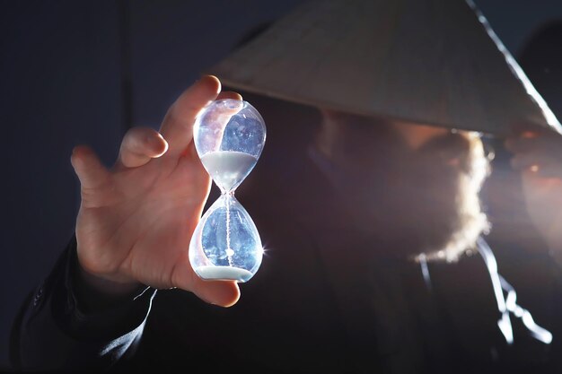 Un homme barbu en costume tient un objet dans sa main. Concept de temps et d'idées. Aspiration et développement.