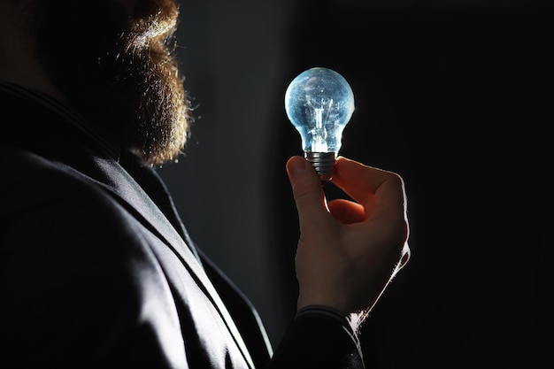 Un homme barbu en costume tient un objet dans sa main Concept de temps et d'idées Aspiration et développement