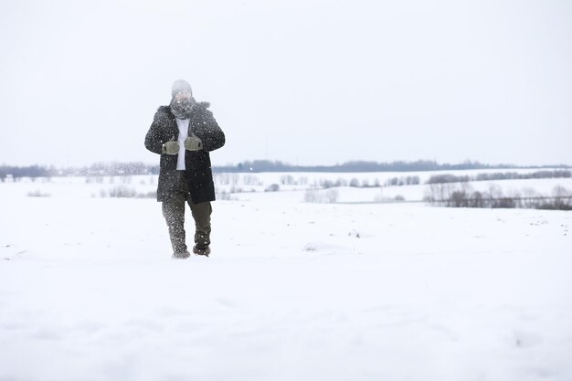 Homme barbu dans les bois d'hiver. Séduisante jeune homme heureux avec barbe marche dans le parc.